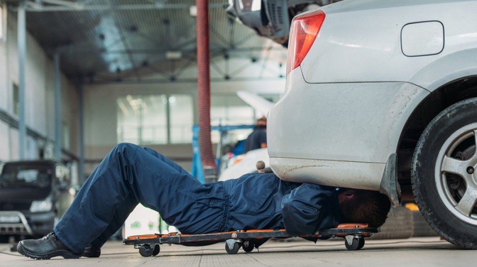 Mechanic working on silver car