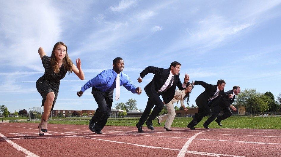 Business professionals running on a high school track