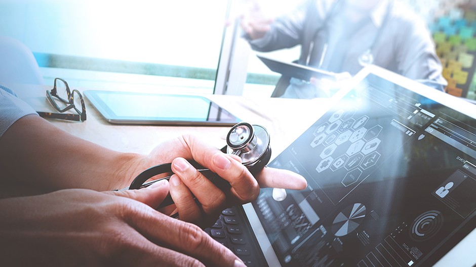 Medical professional looking at data on a computer