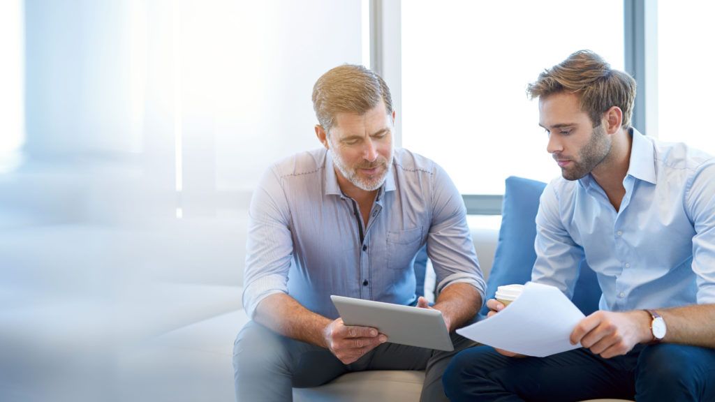 Two men looking at ipad